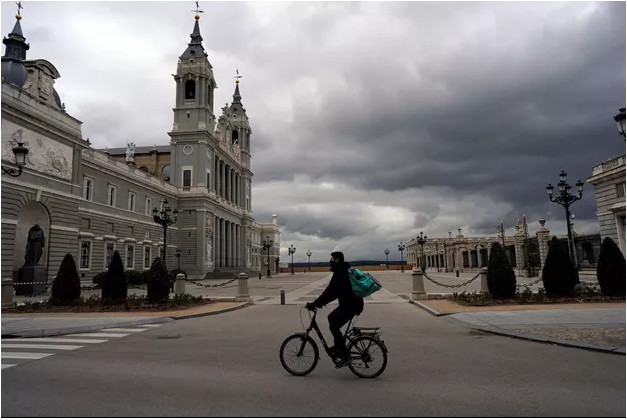 Un homme à vélo sur la Place Royale à Madrid, en Espagne. REUTERS/Juan Medina